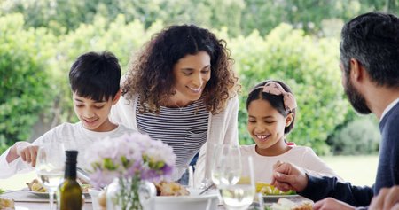 Dinner, parents or children with food outdoor for eating, festive celebration or social gathering. Thanksgiving, people and healthy meal together on patio with care, holiday event and bonding by homeの写真素材