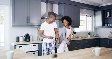 Couple, kitchen and happy with dancing in morning for bonding together, connection and enjoyment. Love, black people and dancer in home for anniversary celebration, relationship and weekend energyの写真素材