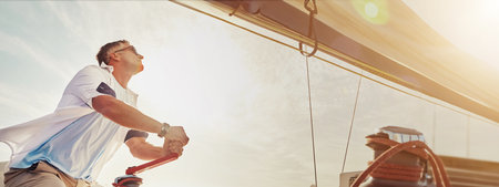 Sailing, yacht and man with winch for travel, adventure and holiday hobby with summer ocean and wind. Sailor, person and luxury ship with sea for vacation, trip and journey for cruise and navigationの写真素材