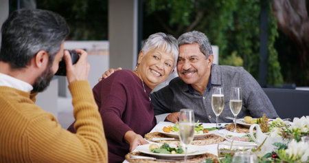 Senior, grandparents and family with food, picture or love with smile, Christmas or social gathering. Elderly, home or people with feast, healthy meal and photograph for happy memory or celebrationの写真素材