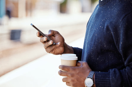 Hand, person and phone for travel with train schedule, metro commute and waiting on transport. Passenger, mobile and communication with coffee break, morning journey and location for subway platformの写真素材