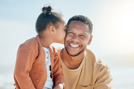 Love, kiss and father with daughter at beach for travel destination, support or summer vacation. Relax, tropical and adventure with man and child for family holiday, bonding and happiness togetherの写真素材