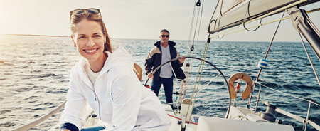 Ocean, banner and couple on boat for travel, vacation and holiday with summer adventure in Greece. People, control and tourists on yacht at beach to relax for sailing trip, steering helm and journeyの写真素材