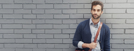 Man, fashion and portrait at brick wall for business, confidence and morning commute at banner. Employee, style and bag at mockup space for creative job, designer and career opportunity in Italyの写真素材