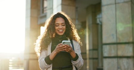 Mobile, realtor and happy businesswoman outdoor for message, check schedule and reading email for mortgage. Phone, smile and real estate agent in city for sale, property listing and laugh at memeの写真素材