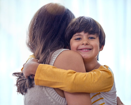 Hug, support and adoption with family at home for foster care, bonding and love. Child welfare, placement success and security with mother and son embrace in living room for happiness togetherの写真素材