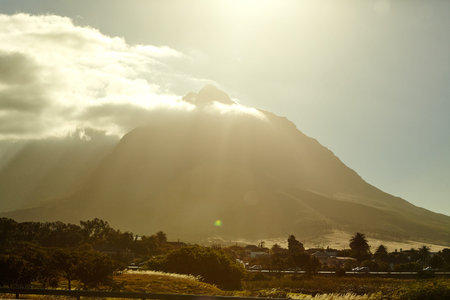 Clouds, sunshine and environment with mountain by city for holiday, scenery and travel destination....