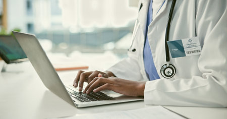 Closeup, doctor and hand for typing on laptop in office, hospital or clinic for communication. Person, medical professional and healthcare with technology for online consultation, email or resultsの写真素材