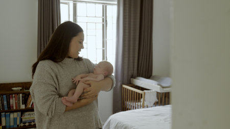 Parent, newborn and mother with baby as care, love or bonding in a home as affection together. Sleeping, support and mom relax in bedroom with kid as family in house for childcare and comfortの写真素材