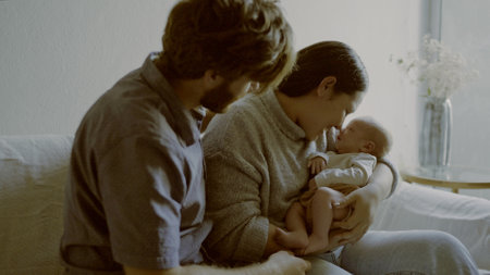 Family, newborn and parents with baby as love, care or bonding in a home playing for fun or affection together. Happiness, dad and mother or couple relax in living room with infant kid in houseの写真素材