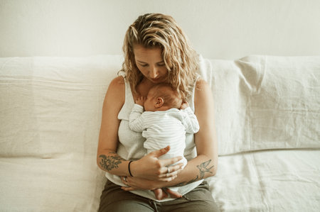 Mother, baby hug and living room in a home with parent care, love on a sofa. Maternity, mama relax and newborn child in a family house with mom and young kid together with youth on a lounge couchの写真素材
