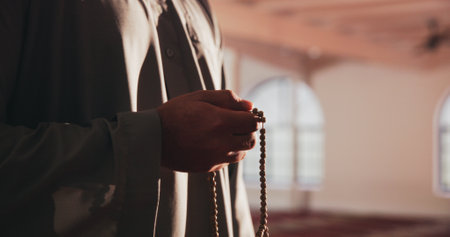 Muslim man, hands and prayer beads in mosque for religion, faith and worship Allah on Ramadan. Islam, holy and person with tasbih in spiritual temple for peace, hope and praise for remembrance on Eidの写真素材