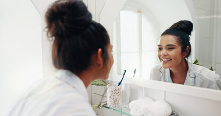 Happy woman, mirror and check for beauty in bathroom with results or face reflection for grooming in...