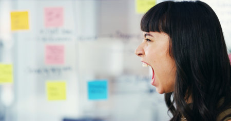 Business, screaming and woman in office, stress and frustrated with project deadline. Profile, employee and consultant in workplace, anger and noise with anxiety, shouting and crisis with conflictの写真素材