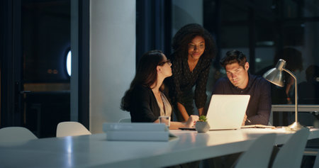 Business people, night and discussion with laptop, planning and brainstorming for legal project and research. Lawyer, consultant and employee with meeting, proposal and deadline idea for case notesの写真素材