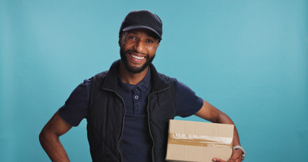 Portrait, courier and happy black man with package in studio for ecommerce, logistics or supply...