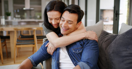 Happy couple, hug and love for man in home, romantic commitment and loyalty in support on couch....