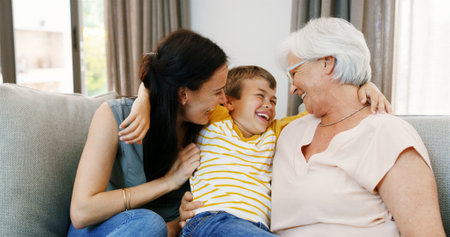 Home, grandma and mom with child for laughing, bonding and playful with games in living room. House, grandmother and parent with boy for connection, funny joke and relationship with group hug on sofaの写真素材