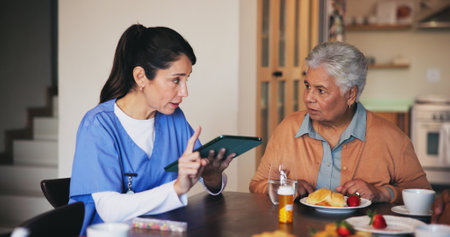 Tablet, discussion and nurse with senior woman at assisted living for diagnosis explanation. Digital technology, medicine and caregiver with elderly patient for dietary information in retirement homeの写真素材