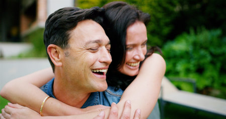 Couple, laughing and hug outdoor by home for bonding, connection and affection in marriage. Happy...
