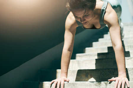 Stairs, fitness and woman doing a pushup as exercise, workout and wellness outdoors for muscle strength on steps. Active, strong and female athlete training outside to be fit and healthy for wellnessの写真素材
