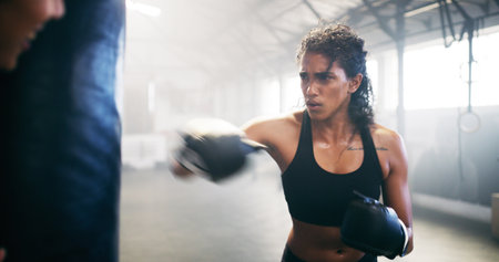 Sports, kickboxing and woman in gym for training, challenge or competition with strength. Fitness, motion blur and female person with coach for cardio workout or exercise in health club for activity.の写真素材