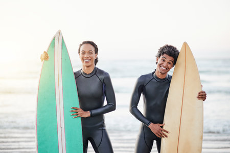 Portrait, sport and surfing friends on the beach together during summer for fun or recreation. Surfboard, water or workout with a man and woman surfer standing in the ocean for training or leisureの写真素材
