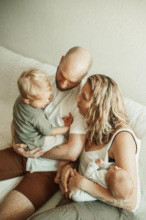 Family in living room, relax and bonding, parents with children at home with love and care in relationship. Childhood, parenting and woman with man, toddler and newborn on couch with time togetherの写真素材