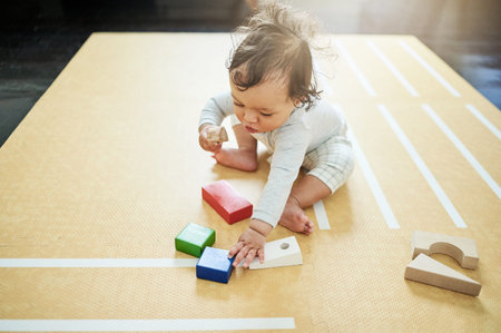 Baby, boy and playing blocks on floor in nursery, childhood growth or childcare development. Kids,...