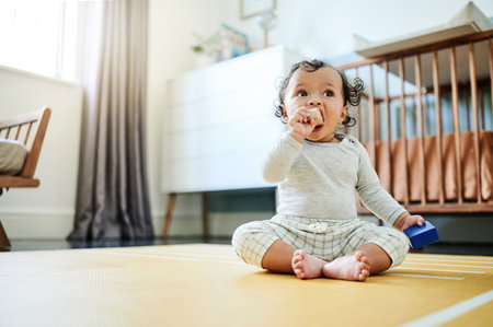 Child development, toys and a baby sitting on the floor in its bedroom at home while playing or looking curious. Children, learning and growth with an adorable little girl kid in a house to playの写真素材