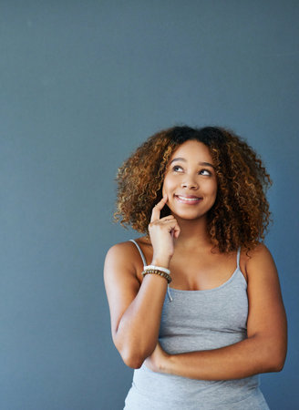Woman, thinking and studio for future inspiration, brainstorming and blue background. Female person, wondering and mockup space for reflection on change or transformation, dream and perspectiveの写真素材