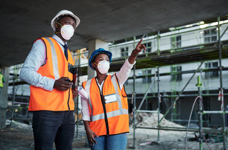 People, meeting and team conversation at construction site, property development and project inclusion. Employees, engineering and pointing to infrastructure, safety gear and outdoor for inspectionの写真素材