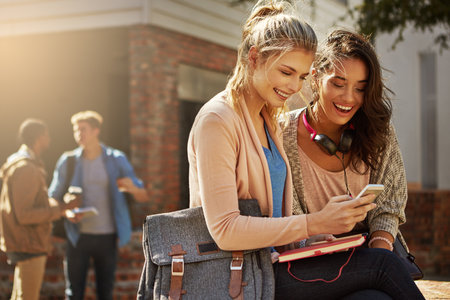 Friends, phone and smile with students in college for social media, outdoor and networking app. Share link, communication and contact with people on University campus for online post and mobileの写真素材