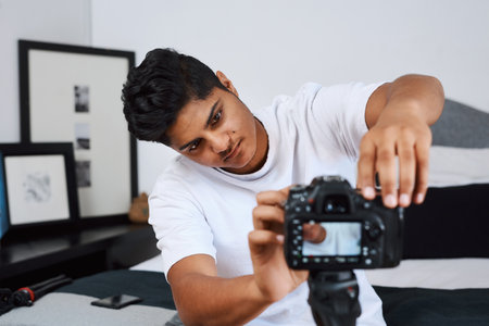 Man, influencer and prepare camera for recording video, content creation or photography in home. Streamer, person and technology for live streaming, filming or setup social media broadcast in bedroomの写真素材