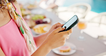 Woman, hands and outdoor with phone for social media, travel planning and contact at hotel event. Influencer, mobile or typing at resort brunch for status update, accommodation review or writing blogの写真素材