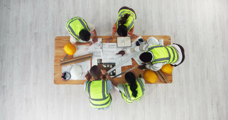 Above, architecture or people in meeting for planning, building design or strategy at space. Engineer team, collaboration or blueprint in office for home renovation, urban development or constructionの写真素材