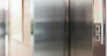 Arrow, button and elevator in office building for up or down direction for arrival at floor of...