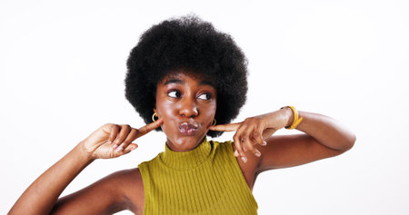 Playful, afro and beauty of black woman with hair care, salon treatment or natural texture in studio. Face, white background or African model with growth, skin glow or facial cosmetics at hairdresserの写真素材