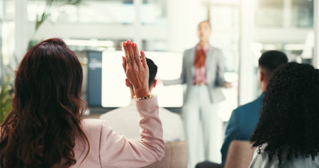 Back, woman and question in seminar for business, vote and opinion feedback. Person, corporate audience and gesture in presentation with idea, employee engagement and volunteer in office meetingの写真素材