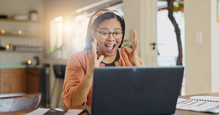 Laptop, surprise and finance with woman in kitchen for home loan approval, tax refund success and budget. Wow, winner and good news with person in house for purchase achievement and trading bonusの写真素材