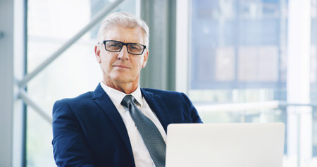 Portrait, glasses and laptop with business man in office for corporate venture capital, email agenda or private equity. Planning, finance return and schedule with mature employee for portfolio assetsの写真素材
