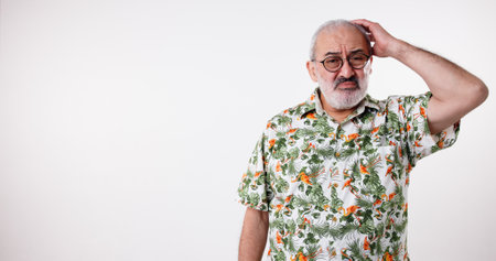 Headache, eyewear and senior man in studio, stress and fatigue on white background. Pensioner, mature person and model with glasses, migraine and frustrated with anxiety, exhausted and mockup spaceの写真素材