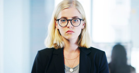 Portrait, glasses and business woman in office, professional and confident tax consultant for compliance. Face, entrepreneur and expert employee, finance and serious fiscal advisor for accountingの写真素材