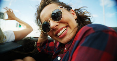 Smile, women and sunglasses in convertible for road trip adventure, travel break and breeze outdoor. People, friends and laugh in sports car with scenery drive, transport journey and summer vacationの写真素材