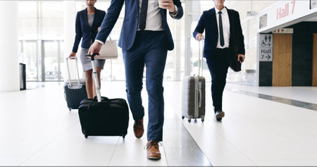 Business people, legs and luggage on travel for international conference with team in lobby. Person, group and lawyer with baggage, suitcase and trip at global convention for corporate law in hallwayの写真素材