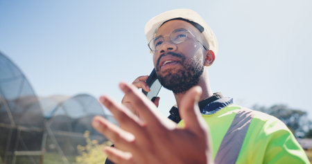 Engineer, man and planning with phone call outdoor for irrigation system project, safety standard and compliance. Agricultural management, black person and update on water control issue and feedbackの写真素材