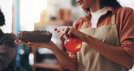 Hands, water and woman with clay in workshop for artistic process, design or production. Creative,...