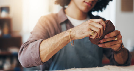 Hands, pottery and man with clay in workshop for artistic process, design or production. Creative, sculpting and male person working on ceramic piece for startup business with manufacturing mud.の写真素材