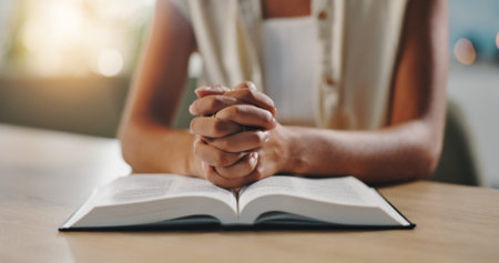 Hands, praying and bible in home with religion, study and hope for change, spiritual or reflection...
