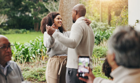 Couple, dancing and outdoor phone for photography, recording passion and love in relationship. Happy people, nature and capture memory of romance in marriage, social media and family easter partyの写真素材